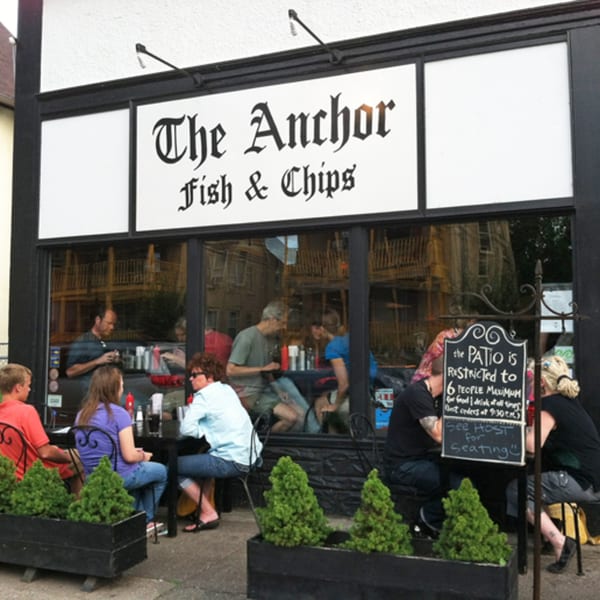 The Anchor Fish & Chips storefront with outdoor patio seating and customers dining inside and out.